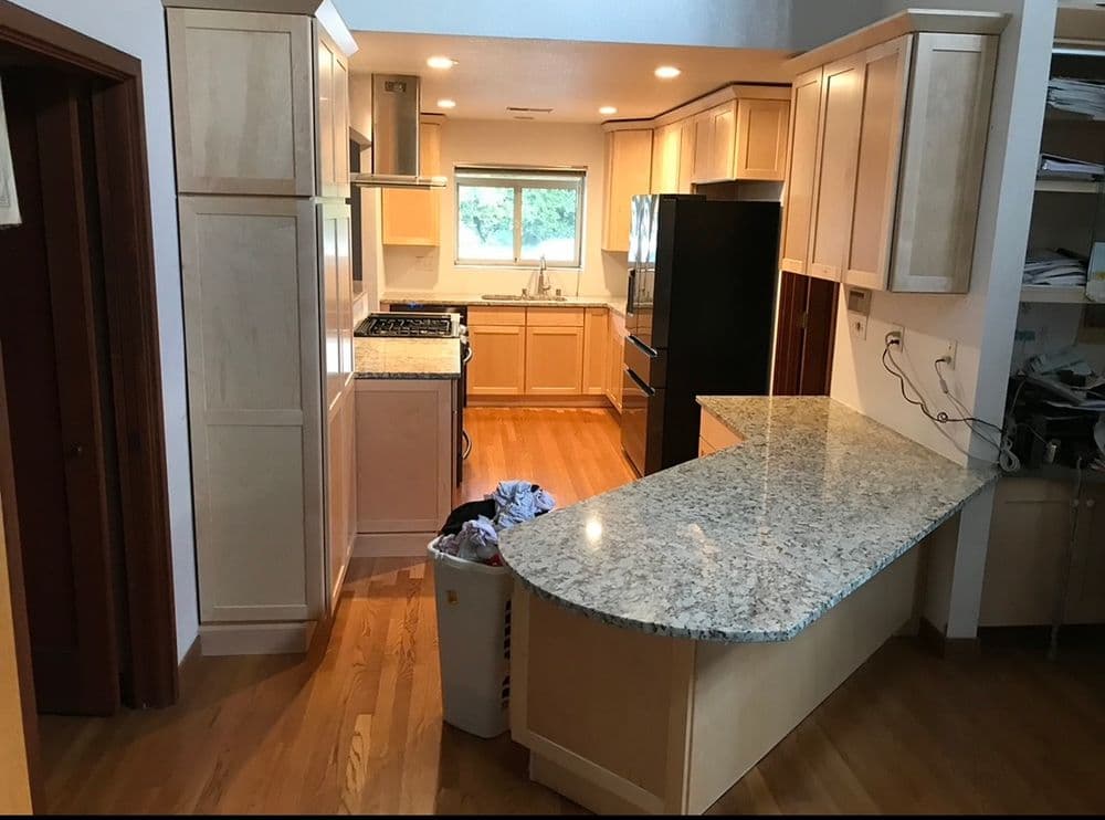 Modern kitchen with granite countertops, wooden cabinets, and stainless steel appliances.