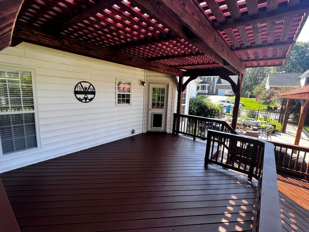 Spacious wooden deck with pergola, featuring seating and outdoor dining area.