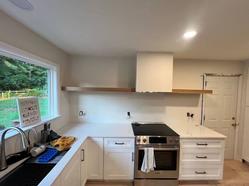 Modern kitchen with white cabinetry, stainless steel appliances, and a minimalist design.