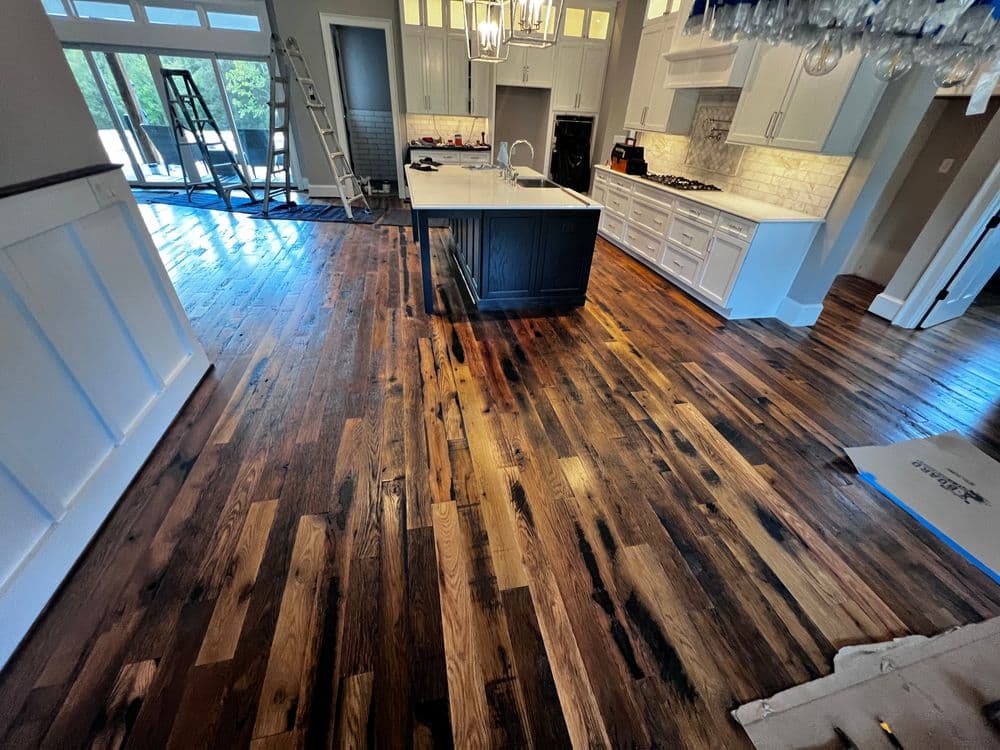 Modern kitchen featuring dark hardwood floors, an island, and bright natural light.