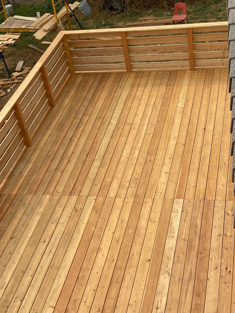 Newly constructed wooden deck with a smooth finish and wooden railing. Ideal for outdoor use.
