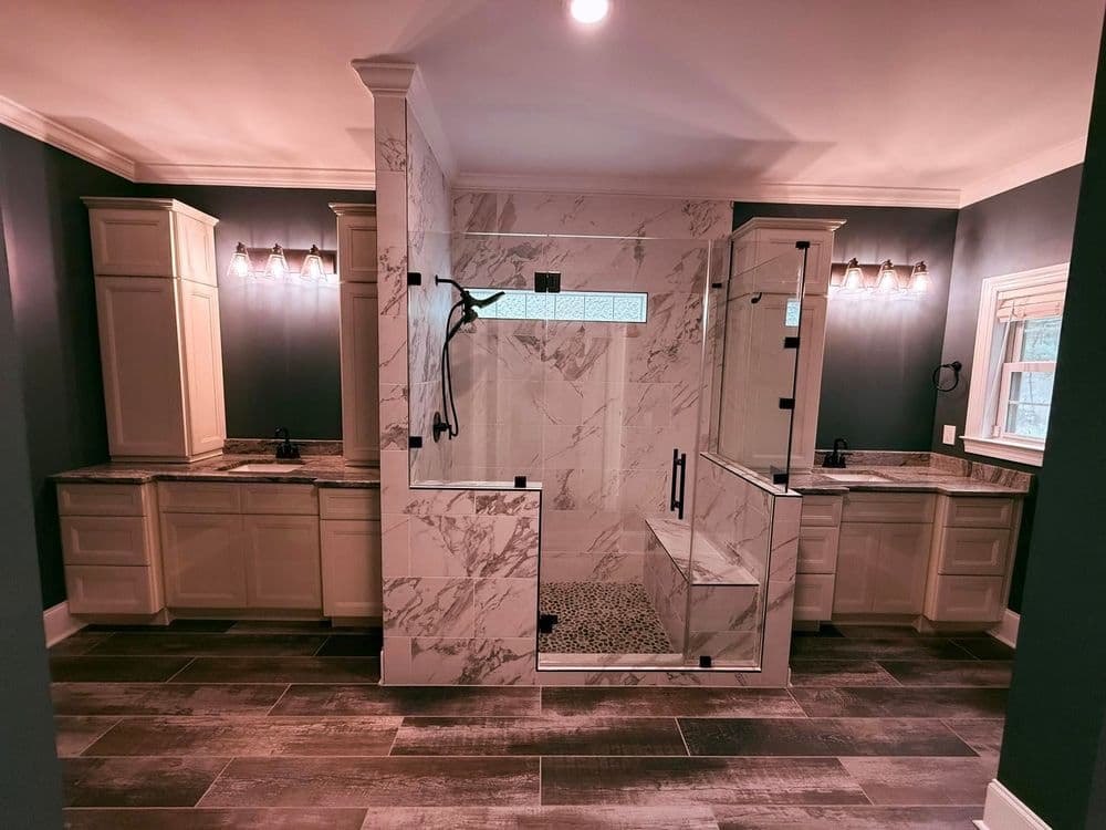 Luxurious modern bathroom with marble shower, dual vanities, and stylish lighting.